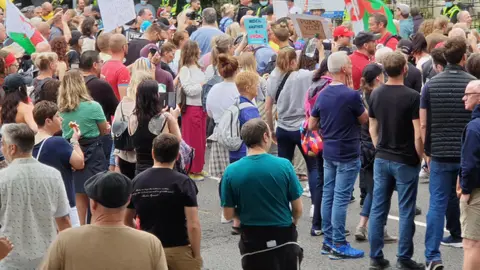 Hundreds of protestors outside the FM's home