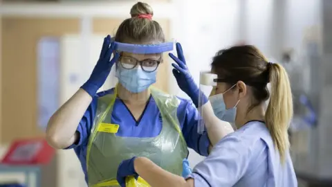 PA Media NHS staff wearing protective equipment