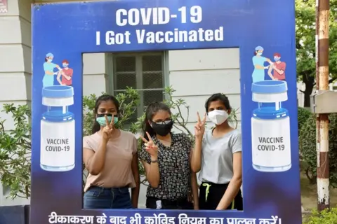 Getty Images Young Indians pose after receiving their vaccinations