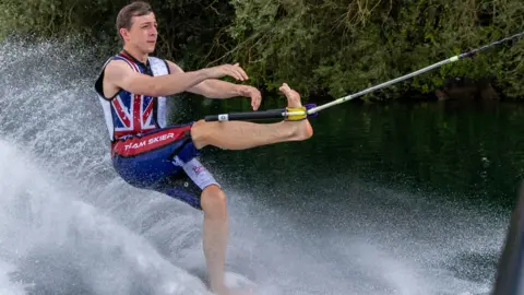 James Elliott Henry water-skiing with his left leg up