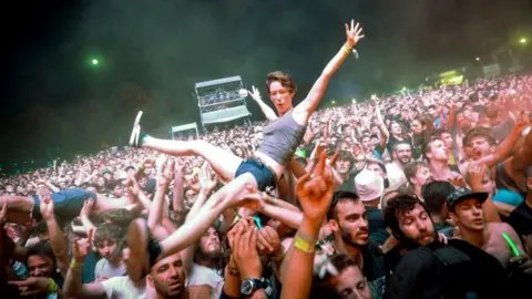 Getty Images A fan crowd-surfs at a rock concert