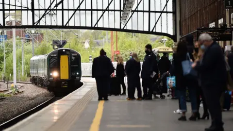 Getty Images Travellers waiting for a train at the station