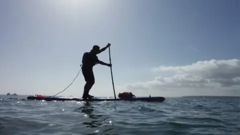 Roy Beal Joe Cartwright on a paddleboard