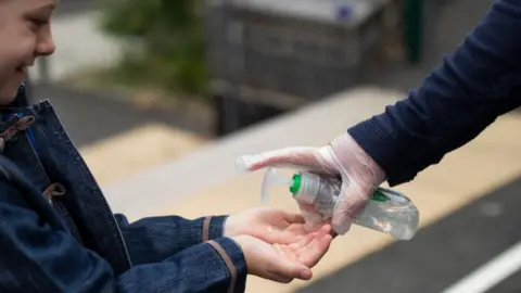 Getty Images Child using hand sanitiser