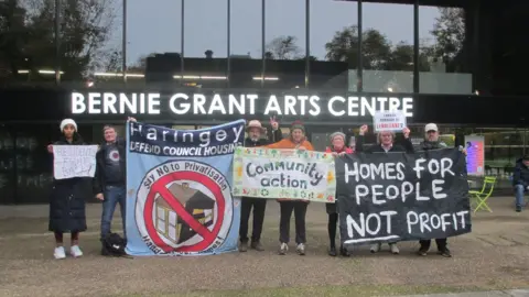 LDRS Seven residents holding banners of various colours and sizes, including one saying 'homes for people not profit'