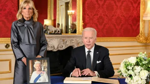 Reuters US President Joe Biden accompanied by the First Lady Jill Biden signs a book of condolence at Lancaster House in London, following the death of Queen Elizabeth II