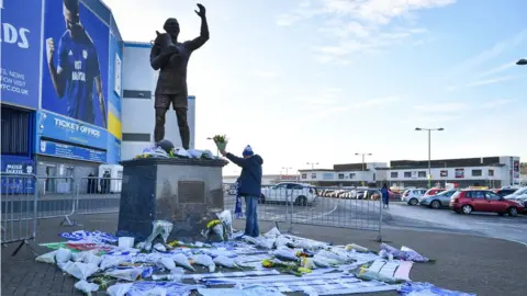 Ben Birchall/PA Wire A fan lays flowers by the statue of Cardiff City footballer Frederick Charles Keenor outside Cardiff City Stadium