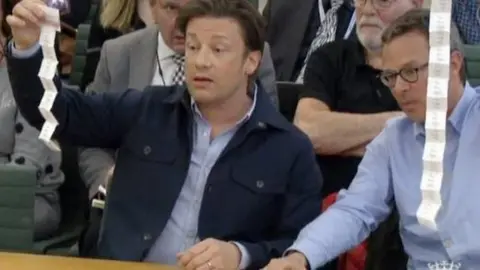 PARLIAMENT TV Jamie Oliver and Hugh Fearnley-Whittingstall demonstrating how many sachets of sugar are in a soft drink