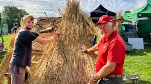 Two men handling straw at the Widecombe Fair