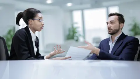 Getty Images Colleagues working together during discussion in office