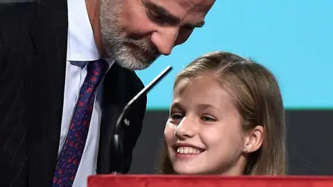 AFP The King of Spain smiles at his daughter, Princess Leonor, as she peeks over the top of a podium almost as tall as she is