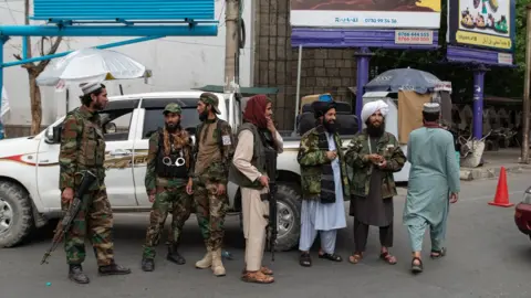 Nava Jamshidi/BBC Taliban fighters stand at a checkpoint in Kabul, September 2022