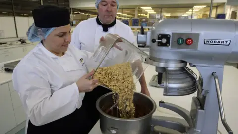 WPA Pool/Getty Images Bakers in Stockport practising the Rich Tea biscuit cake for the royal wedding