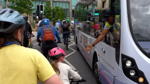 A bus driver high-fiving a girl