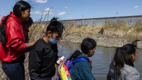Getty Images Migrants at the Mexico-Texas border on 7 March