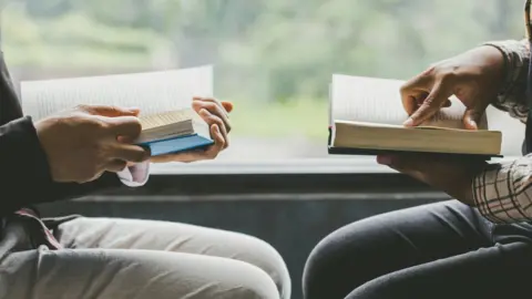 Getty Images Two people reading books