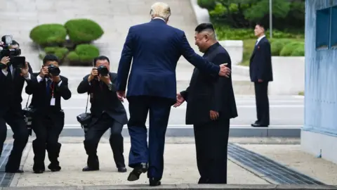 Getty Images Mr Trump steps into the northern side of the military demarcation line dividing the two Koreas