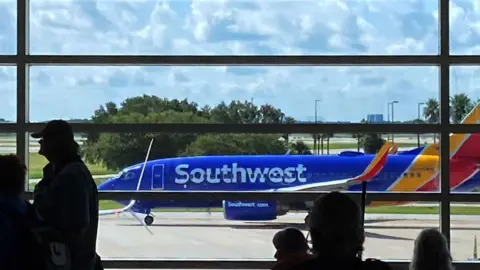 A Southwest Airlines plane taxis on the tarmac in preparation for takeoff at Orlando International Airport.