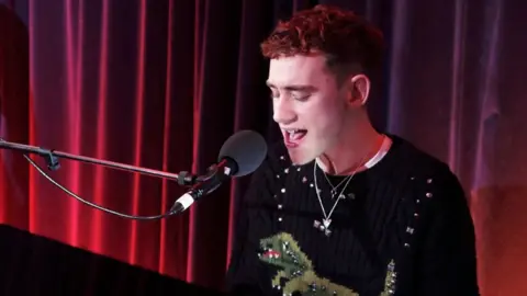 Photo of Olly Alexander singing into a microphone