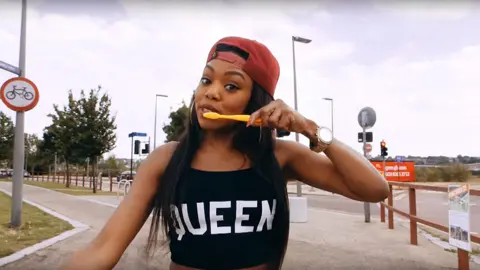 Lady Leshurr/YouTube Lady Leshurr brushing her teeth in the Queen's Speech 4