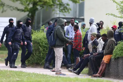 Getty Images Picture of police intervening at a refugee centre