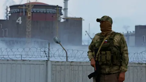 Reuters A Russian soldier guards near the Zaporizhzhia nuclear power plant. Photo: August 2022