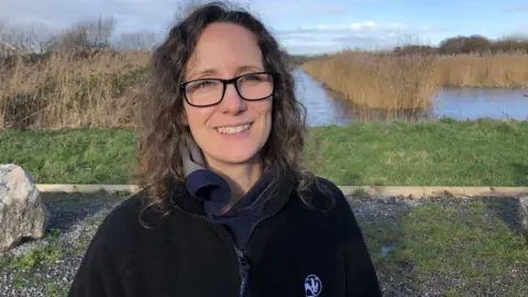 AFP A woman with curly hair and glasses outside