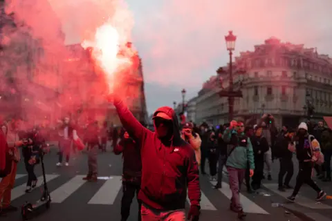 Lafargue Raphael/ABACA/REX/Shutterstock Protester hold a flare on the place de l opera during a demonstration, a week after the government pushed a pensions reform through parliament without a vote, using the article 49.3 of the constitution, in Paris on March 23, 2023.