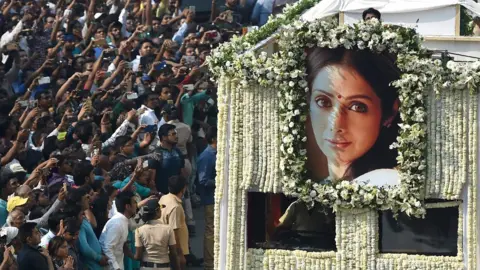 Getty Images Indian fans watch as the funeral cortege of the late Bollywood actress Sridevi Kapoor passes through Mumbai, 28 February 2018