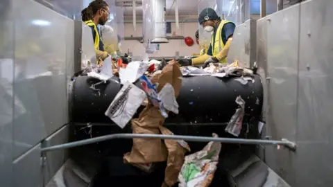BBC Photo of two people sorting recycling