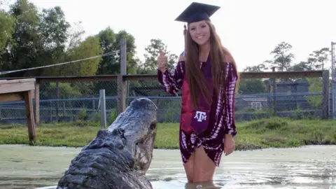 Makenzie Noland Makenzie gives thumbs up to camera posing with the alligator