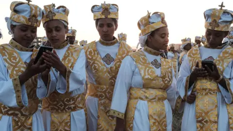 AFP Orthodox Ethiopians using smart phones in Addis Ababa - January 2019