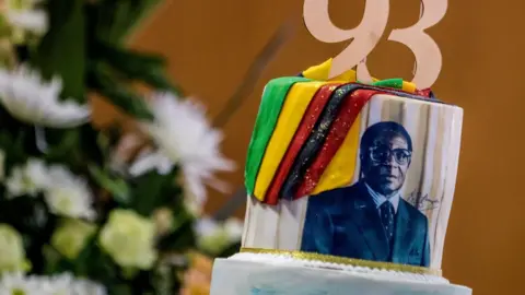 Getty Images A picture taken on February 21, 2017 shows a cake bearing a portrait of Zimbabwe's President Robert Mugabe during a private ceremony to celebrate Mugabe's 93rd birthday in Harare. Mugabe, the world's oldest national ruler, turned 93, using a long and occasionally rambling interview to vow to remain in power despite growing signs of frailty.