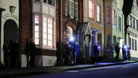 Reuters People light up their cell phones while they stand outside, as part of a day of reflection to mark the anniversary of Britain's first coronavirus disease (COVID-19) lockdown, in Lichfield, Britain March 23, 2021