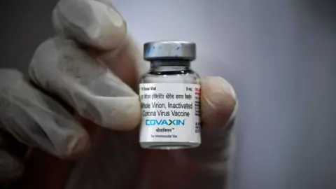 Getty Images A medical worker displays a vial of the Covaxin vaccine against the Covid-19 coronavirus at a vaccination centre in Mumbai on May 9, 2021.