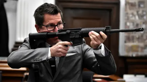 Reuters Assistant District Attorney Thomas Binger holds Kyle Rittenhouse"s gun as he gives the state"s closing argument in Kyle Rittenhouse"s trial Kenosha County Courthouse, Wisconsin