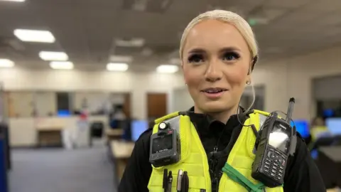 Emma Baugh/BBC Police officer in police station