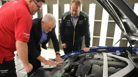 Getty Images Jeremy Corbyn with Aston Martin chief executive Andy Palmer (right) and quality inspector Barry Griffin (left) during the Labour leader's visit to the car maker's Warwick factory last November