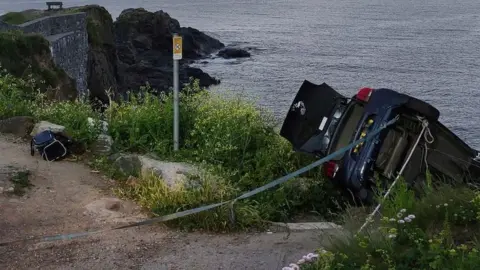 Mullion Coasguard Rescue Team Car on its side secured with strap