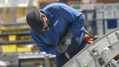 Getty Images An Airbus' employee works on an aircraft part of the Airbus A350 at the Airbus Atlantic plant in Bouguenais, near Nantes, western France