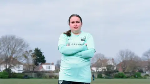 Holly Lewis Holly Lewis, pictured outside in a football shirt