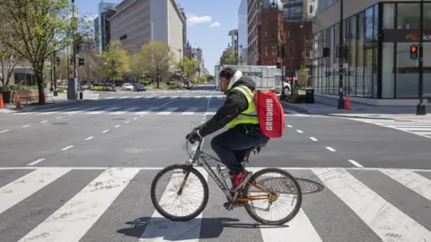 EPA Grubhub delivery person Tayy Evans makes bicycle deliveries on the empty streets of Washington, DC, USA, 02 April 2020