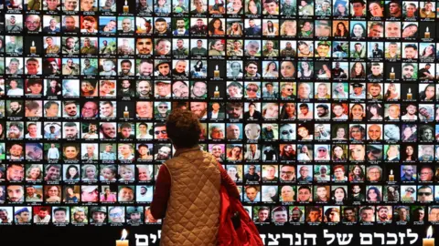 EPA A large screen at the National Library of Israel in Jerusalem projects Israeli victims of the 7 October attack and the soldiers who were killed in the subsequent fighting in Gaza