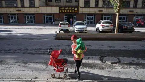 Getty Images A woman and a child in Aksu, Xinjiang