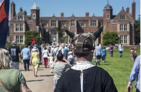 BBC The procession heads to Kentwell Hall for the play