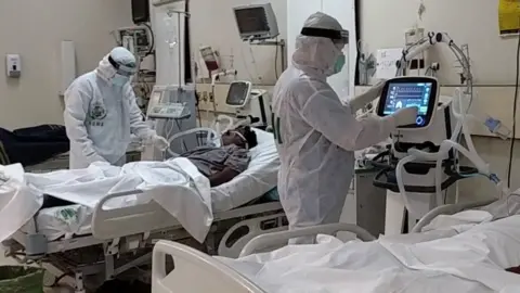JPMC Two doctors work on patients in intensive care