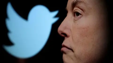 Reuters Elon Musk's side profile in front of a Twitter logo