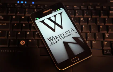 Getty Images/PeterMacdiarmid A mobile device shows Wikipedia's front page displaying a darkened logo on 18 January, 2012
