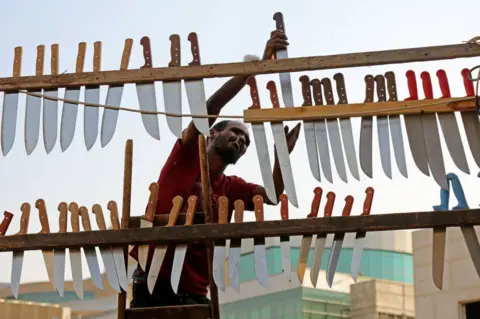 Getty Images An Egyptian worker hangs knives at a blade sharpening shop at a popular market on July 3, 2022 in Cairo, Egypt.