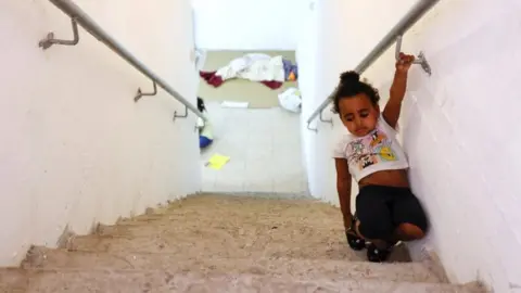 Reuters A child walks on stairs inside a bomb shelter in Ashkelon, southern Israel, on May 16